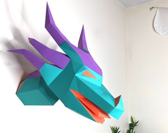 May include: A teal and purple paper dragon head wall sculpture. The dragon has a wide open mouth with an orange tongue and orange eyes.