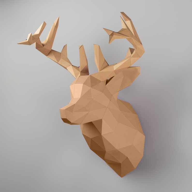 May include: A brown paper mache deer head with large antlers. The deer head is a 3D sculpture with a geometric design.