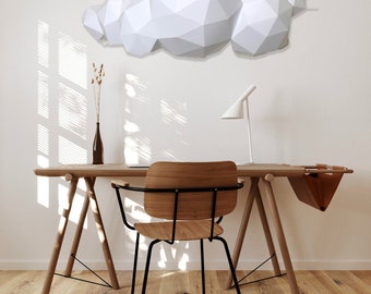 Puede incluir: Una escultura de nube de papel blanco geométrico que cuelga de una pared blanca sobre un escritorio de madera con una silla. El escritorio tiene una bolsa de cuero marrón colgada en el lateral.
