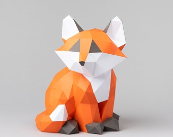 Pode incluir: Uma figura de raposa de papel em laranja, branco e cinza. A raposa está sentada com a cabeça inclinada para o lado e a cauda enroscada atrás dela.