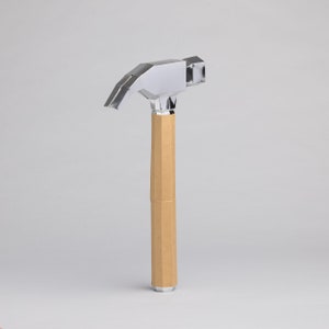May include: A silver hammer with a brown cardboard handle.