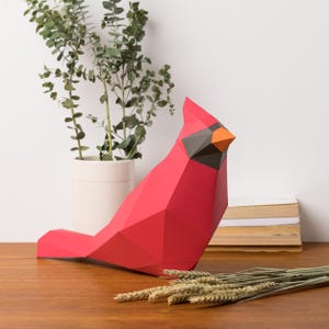 Scultura in carta 3D raffigurante un cardinale rosso. Riceverai modelli in formato SVG e PDF e istruzioni per realizzare questa scultura in carta low poly fai da te.