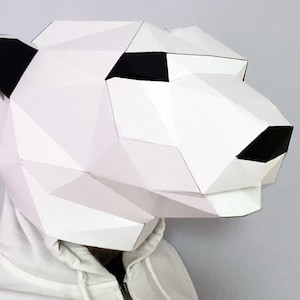 Maschera di carta a forma di orso polare in 3D. Ottieni il modello in formato SVG, PDF e le istruzioni per questa maschera di carta low poly in 3D fai da te.