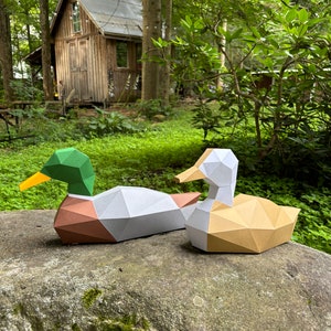 Papercraft 3D a forma di anatre. Riceverai i modelli e le istruzioni per realizzare questa scultura di carta low poly fai da te in formato SVG e PDF.