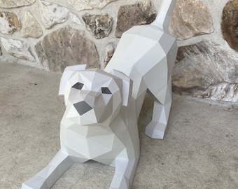 May include: A white papercraft dog sculpture in a playful pose. The dog is made of folded paper and has a realistic appearance.