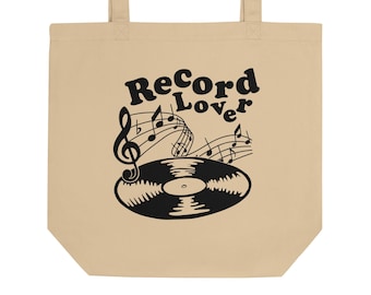 Op de afbeelding: Een beige tote bag met zwarte tekst die "Record Lover" zegt en een zwarte illustratie van een vinylplaat met muzieknoten.