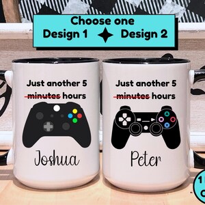 May include: Two white ceramic mugs with black handles and rims. Each mug features a black video game controller graphic and the text "Just another 5 minutes hours". One mug is personalized with "Joshua", the other with "Peter".