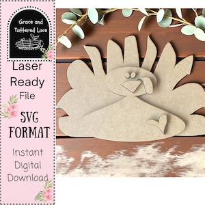 May include: A laser-ready wooden turkey cutout in a light brown color. The turkey has a heart-shaped detail and is set against a brown wooden background. The image also includes text that says "Laser Ready File SVG Format Instant Digital Download."