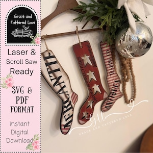 May include: Three wooden Christmas stocking ornaments. One is red with white stars and the words "Vintage & Collectibles". Another is striped red and white with "Antiques". The third is cream with "Mercantile".