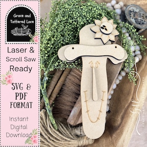 May include: A light-colored wooden cutout of a scarecrow face featuring a wide-brimmed hat with a sunflower accent, a long nose, and a stitched mouth. The design includes two small holes at the hat brim for hanging and is intended for laser or scroll saw use.