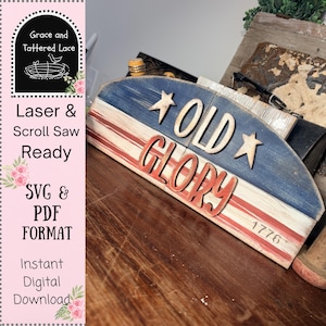 May include: A wooden sign with a patriotic theme, featuring the words "OLD GLORY" and the number "1776". The sign is painted with red, white, and blue colors, resembling the American flag. The sign is ready for laser and scroll saw.