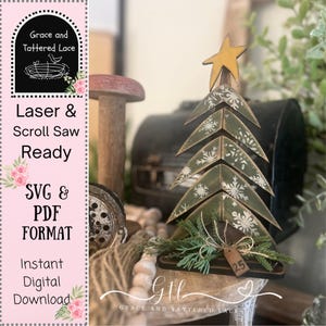 May include: A wooden Christmas tree with a star topper and snowflake details. The tree is painted green with white snowflakes and has a small tag that says "25". The image also includes the text "Laser & Scroll Saw Ready" and "SVG & PDF FORMAT".