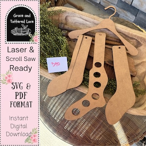 May include: A collection of unfinished wooden sock cutouts and a hanger, perfect for crafting. The image includes the text "Laser & Scroll Saw Ready" and "SVG & PDF FORMAT". A small white card displays the number "390".