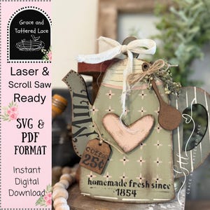 May include: A decorative wooden teapot with a distressed, vintage aesthetic. The teapot is painted in shades of green and pink, with a heart-shaped accent and a small tag that reads "Coffee 25¢". The text "homemade fresh since 1854" is also visible.