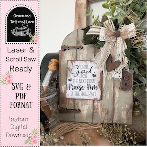 May include: A rustic wooden door with a sign that reads "Until God Opens The Next Door Praise Him In The Hallways." The door is painted in shades of green and brown, with decorative elements like a bow and heart.