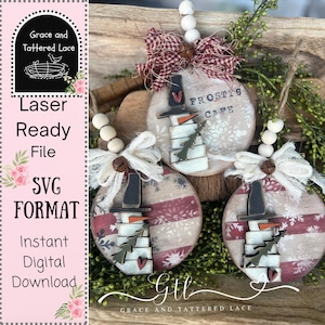 Op de afbeelding: Drie ronde houten kerstornamenten met sneeuwpopontwerpen en de tekst "Frosty's Cafe". De ornamenten hebben rood-witte strepen en zijn versierd met witte kralen en strikken. Elke sneeuwpop heeft een zwarte hoed en een wortelneus.