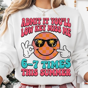 Peut inclure: Sweat-shirt blanc avec l'inscription "ADMIT IT YOU'LL LOW KEY MISS ME" en rose et rouge. Un smiley avec des lunettes de soleil et des palmiers est au centre. Le texte "6-7 TIMES THIS SUMMER" est en dessous en bleu et rose.