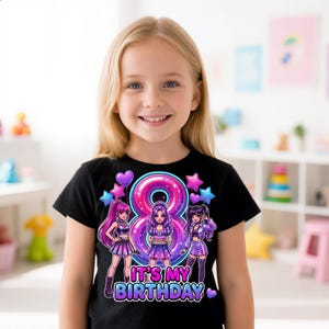 Op de afbeelding: Een zwart t-shirt met korte mouwen voorzien van een kleurrijke afbeelding van drie anime-stijl figuren, een groot roze en blauw cijfer acht, en de tekst IT'S MY BIRTHDAY. Het ontwerp bevat paarse en blauwe sterren en hartvormige ballonnen.