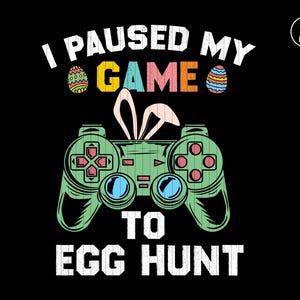 Puede incluir: Un mando de videojuego verde y negro con orejas de conejo y el texto "Pausé mi juego para la búsqueda de huevos" con huevos de Pascua coloridos a cada lado de la palabra "juego".