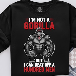 May include: Black sweatshirt featuring a gorilla graphic and the text "I'M NOT A GORILLA BUT I CAN BEAT OFF A HUNDRED MEN" in red and white. The gorilla is depicted with a muscular build and a fierce expression.