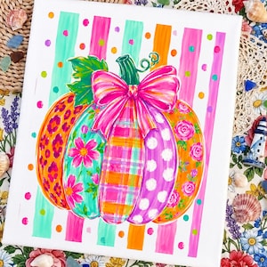 Peut inclure: Une peinture sur toile rectangulaire représentant une citrouille centrale ornée de divers motifs, dont des taches de léopard, des fleurs roses, des carreaux, des pois blancs et des roses, surmontée d'un grand nœud rose vif et d'une tige verte.