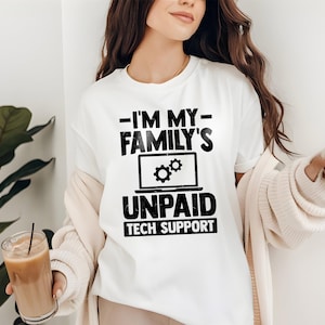 Peut inclure: T-shirt blanc avec l'inscription "-I'M MY- FAMILY'S UNPAID TECH SUPPORT" en noir. Le motif comprend un ordinateur portable avec des icônes d'engrenages. Le t-shirt est de style décontracté et unisexe.