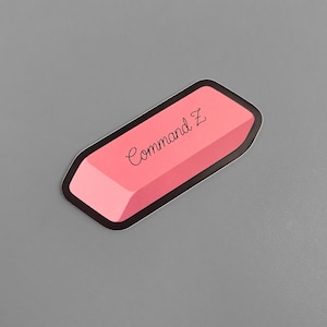 May include: Pink eraser sticker with black outline and the text "Command Z" written in black cursive.