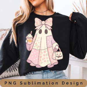 Puede incluir: Sudadera negra con un diseño de fantasma. El fantasma lleva un lazo rosa, un atuendo de patchwork con estampados florales y de corazón, y sostiene un café con leche de calabaza y una bolsa de truco o trato. El texto "PNG Sublimation Design" está en la parte inferior.