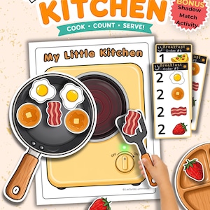 Puede incluir: Un juego de conteo de desayuno My Little Kitchen que incluye una ilustración de estufa amarilla, una sartén negra con huevos, tocino y panqueques, una espátula negra, tarjetas de pedido y un plato de madera con un gráfico de fresa.