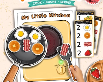 May include: A My Little Kitchen breakfast counting game featuring a yellow stove illustration, a black frying pan with eggs, bacon, and pancakes, a black spatula, breakfast order cards, and a wooden plate with a strawberry graphic.