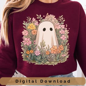 Puede incluir: Sudadera burdeos con un diseño floral de fantasma. El fantasma tiene dos ojos negros y está rodeado de flores rosas, amarillas y naranjas. Las palabras "Digital Download" están en la parte inferior.