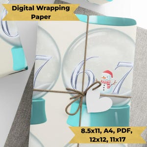 May include: Digital wrapping paper featuring a snow globe design with the numbers 6 and 7. The snow globe has a snowman wearing a red hat and scarf. The paper is tied with twine and a white heart-shaped tag. The text "Digital Wrapping Paper" and paper size options are visible.