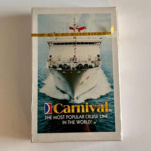 May include: A sealed deck of Carnival cruise line playing cards. The box features a large image of a cruise ship sailing on the ocean. The Carnival logo is displayed with the text "THE MOST POPULAR CRUISE LINE IN THE WORLD!"