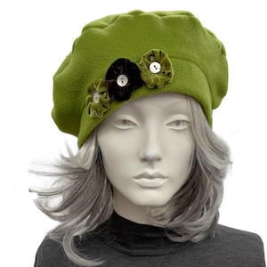 May include: A lime green fleece beret featuring three decorative fabric rosettes in shades of olive, dark brown, and light green. Each rosette is centered with a small, round, white button, creating a textured floral accent on the side.