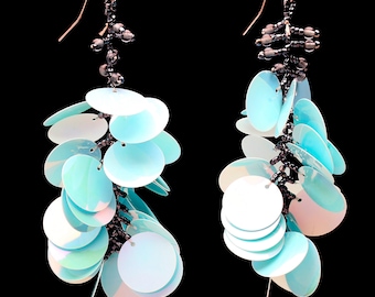 Long dangling statement earrings made with large light blue sequin paillettes and glass seed beads