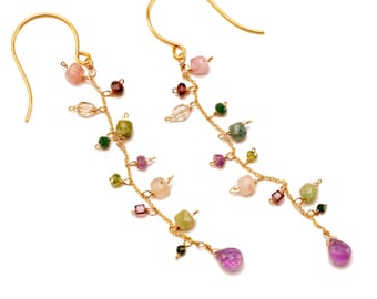 May include: Gold-tone dangle earrings featuring a delicate vine design. The earrings are adorned with a variety of colorful gemstones, including pink, green, purple, and clear beads. The earrings have a hook closure.