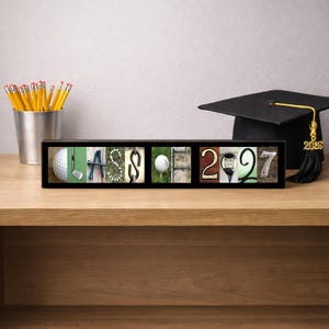 Puede incluir: Un marco negro rectangular que contiene ocho azulejos fotogr&aacute;ficos cuadrados que deletrean la palabra CLASS y el n&uacute;mero 2027. Cada letra y d&iacute;gito est&aacute; formado por im&aacute;genes de golf, incluyendo pelotas, palos, tees y elementos del campo.