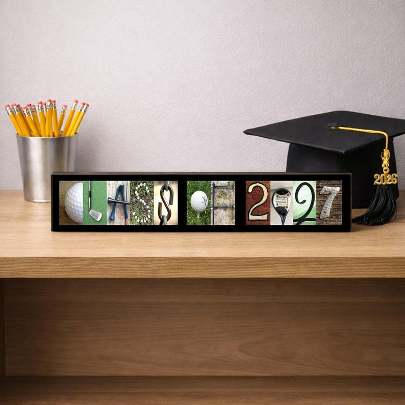 Puede incluir: Un marco negro rectangular que contiene ocho azulejos fotogr&aacute;ficos cuadrados que deletrean la palabra CLASS y el n&uacute;mero 2027. Cada letra y d&iacute;gito est&aacute; formado por im&aacute;genes de golf, incluyendo pelotas, palos, tees y elementos del campo.