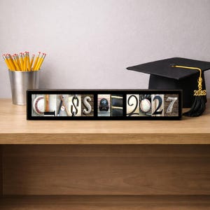Puede incluir: Un marco negro rectangular que contiene una serie de fotograf&iacute;as que deletrean la palabra CLASS 2027. Cada letra y n&uacute;mero est&aacute; formado por im&aacute;genes de b&eacute;isbol, incluyendo pelotas, bates, guantes y gorras, sobre un fondo de madera.