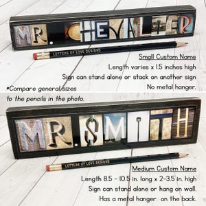 Puede incluir: Dos letreros de nombre personalizados con marcos negros y dise&ntilde;os de letras desgastadas. El letrero superior dice "MR. CHEVALIER" y el inferior "MR. SMITH". Un l&aacute;piz con "LETTERS OF LOVE DESIGNS" est&aacute; frente a cada letrero. El letrero peque&ntilde;o mide 3,8 cm de alto.
