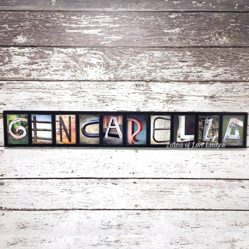 Puede incluir: Una obra de arte enmarcada que deletrea el nombre "GENCARLA" utilizando bloques de letras individuales. Cada letra presenta una imagen de fondo &uacute;nica, con un fondo de madera envejecida. El texto "Letters of Love Designs" est&aacute; en la parte inferior.