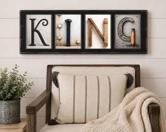 Könnte beinhalten: Ein rechteckiges Wandschild mit schwarzem Rahmen, das vier einzelne Paneele enthält, die das Wort KING bilden. Jeder Buchstabe besteht aus industriellen Objekten, darunter ein K aus Metall, ein vertikaler Bolzen, Holzbalken für das N und ein C aus Metall.