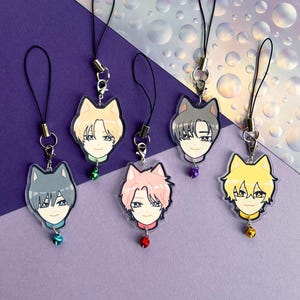 May include: A collection of anime-style acrylic charms featuring stylized wolf heads with human faces. Each charm has a different hair color and a small bell attached. The charms are suspended from black lanyards with silver-colored hardware.