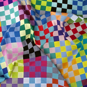 May include: A colorful fabric with a checkered pattern in various colors, including red, blue, green, yellow, and pink. The fabric is folded and draped, creating a dynamic and textured surface.