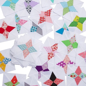 May include: A collection of fabric squares with a star design in the centre. The squares are made of various patterned fabrics, including floral, polka dot, and plaid. The squares are arranged in a random pattern on a white background.