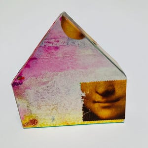 Escultura de casa espiritual hecha con collage: imágenes encontradas, pájaros, arte con libros, sellos postales.