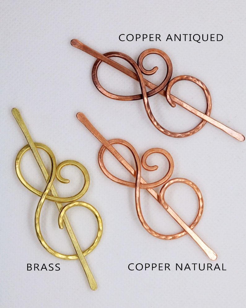 May include: Three hair clips in different finishes: copper antiqued, copper natural, and brass. Each clip features a decorative swirl design.
