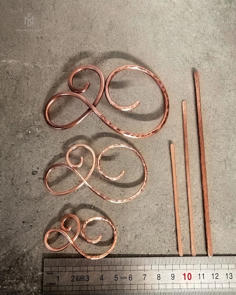 May include: Three copper hair pins, two are curly and one is straight. The curly hair pins are hammered and come in three sizes. The straight hair pin is 10 cm long.