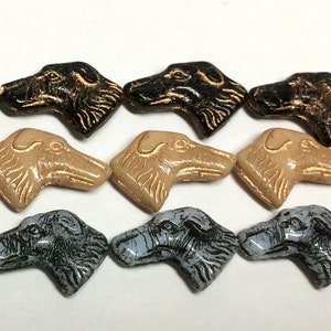 May include: Rows of dog-shaped beads in various colors: black with gold accents, tan, and gray with blue accents. The beads are strung on white thread and are suitable for jewelry making.