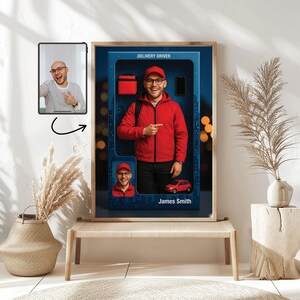 May include: A framed print featuring a delivery driver in a red jacket and cap, pointing. The print includes a small red car, a bag, and a phone. A smaller image of the driver and a tablet with a photo are also included. The text "Delivery Driver" is at the top.